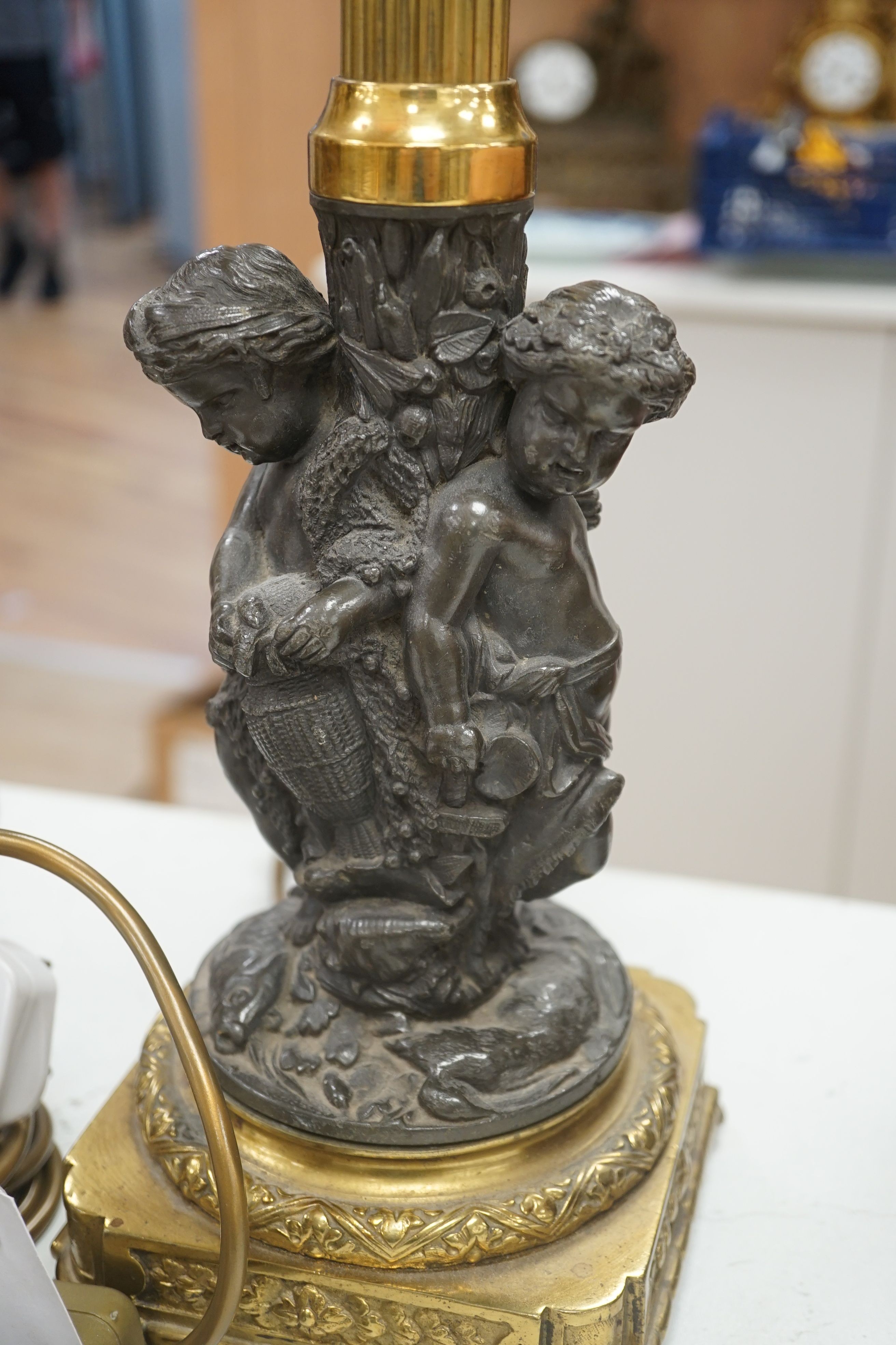 Two bronze or ormolu cherubic table lamps, one with shade. Tallest 58cm total